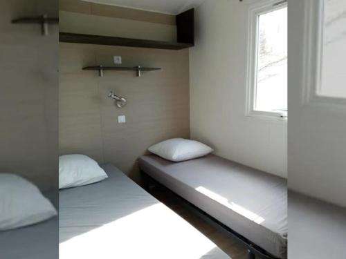 Ένα ή περισσότερα κρεβάτια σε δωμάτιο στο Mobil-home cosy avec terrasse à Tréguennec - API-1-52-977