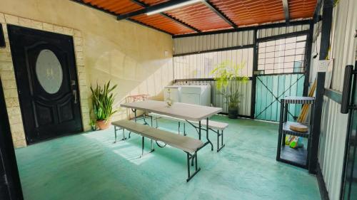 a patio with a table and benches in a room at Casa Rio Lagartos in Río Lagartos