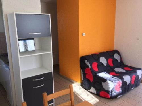 Una sala de estar con una silla y una estantería. en Chalet avec terrasse pour 4 personnes à Oloron-Sainte-Marie - API-1-52-954, en Bidos