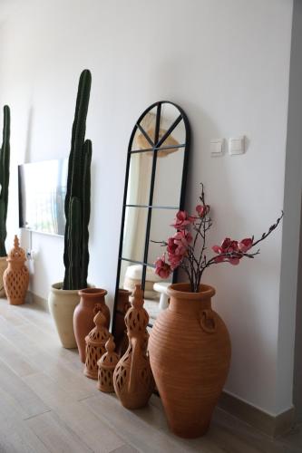 Eine Gruppe von Vasen mit Blumen darin stand auf dem Boden. in der Unterkunft Desert Retreat Canal View walk to F1 Yas Island in Abu Dhabi