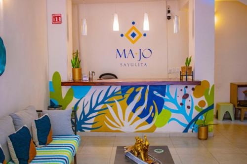 a living room with a couch and a sign on the wall at Hotel Majo Sayulita in Sayulita