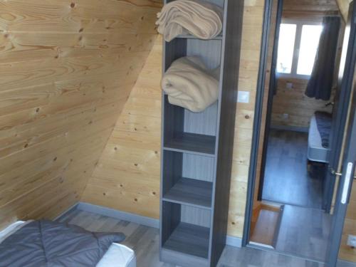 a room with a wooden wall with shelves and towels at Chalet pour 6 avec Terrasse - La Chapelle-devant-Bruyères - API-1-52-972 in La Chapelle