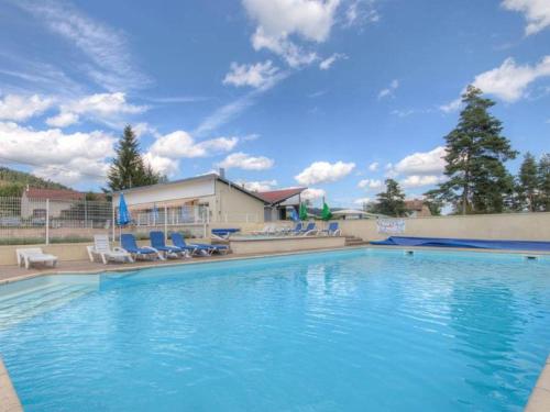 a large swimming pool with chairs and a building at Chalet 3 Chambres avec Terrasse - Parfait pour 6 Personnes - API-1-52-991 in La Chapelle