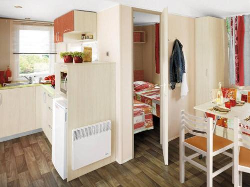 Mobil-home 28m² avec terrasse à Saint-Rome-de-Tarn - API-1-52-993 في Saint-Rome-de-Tarn: مطبخ صغير مع طاولة وغرفة طعام