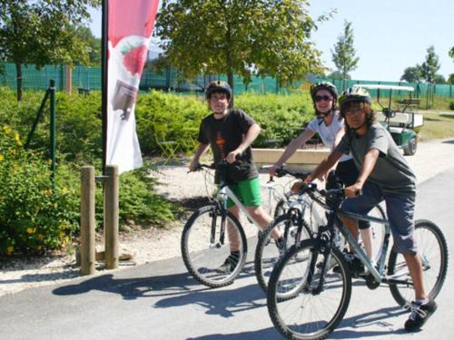Tres personas andando en bicicleta por una calle en Chalet - Terrasse - API-1-52-1003, en Chemillé-sur-Indrois