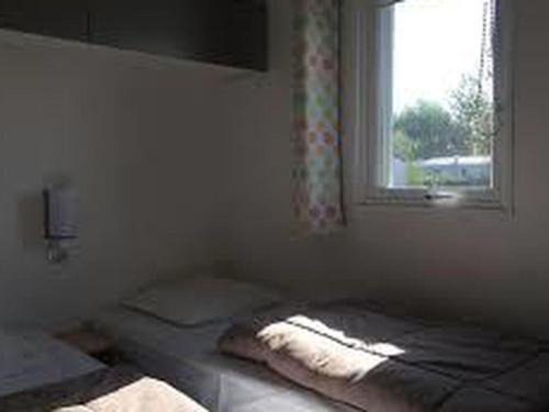 a bedroom with two twin beds and a window at Mobil-home 38m² avec terrasse pour 6 personnes - API-1-52-1008 in Luynes
