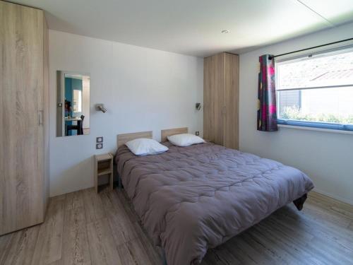 Un dormitorio con una cama en una habitación con ventana. en Mobil-home PMR avec Terrasse à Saint-Rome-de-Tarn - API-1-52-1012, en Saint-Rome-de-Tarn