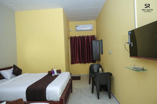 a hotel room with a bed and a tv at sky suite residency in Auroville