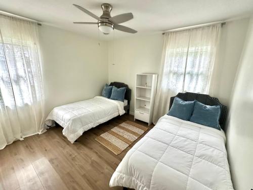 a bedroom with two beds and a ceiling fan at CASA SOLÉ, South Tampa in Tampa