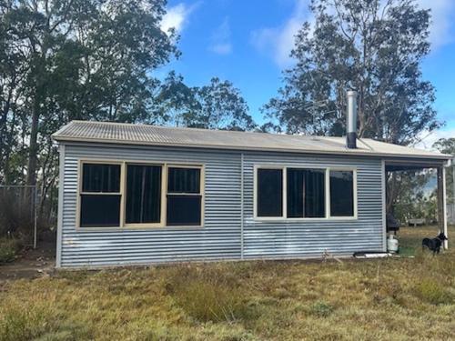 a house with a dog standing in front of it at Quiet Rural Retreat - Kimbriki in Mount George