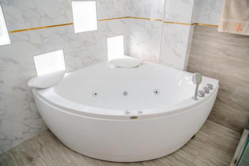 a white bath tub in a bathroom with marble walls at HOTEL TERRANOVA Abancay in Abancay