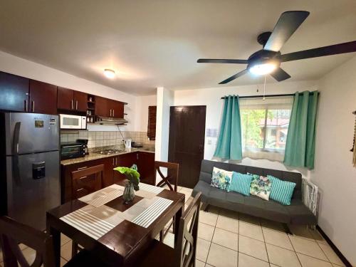 eine Küche und ein Wohnzimmer mit einem Tisch und einem Deckenventilator in der Unterkunft Cocomarindo Breeze Condo and Amazing Pool in Coco