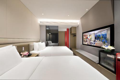 a hotel room with two beds and a flat screen tv at Mercure Beijing Tiananmen Square Qianmen Street in Beijing