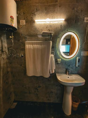 a bathroom with a sink and a mirror at Khoj The Lake Trail in Nārkanda