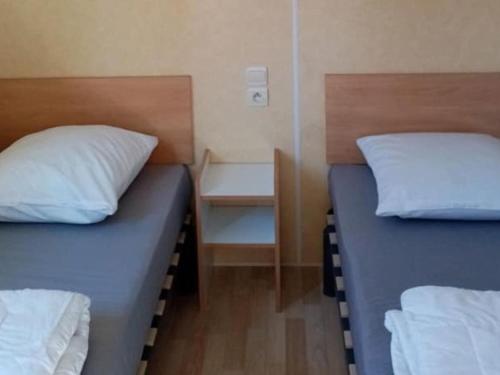 2 letti in una piccola camera con di Mobil-home confortable avec terrasse pour 4 personnes à Tréguennec - API-1-52-1029 a Tréguennec