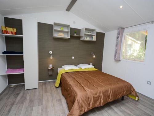 Un dormitorio con una cama grande en una habitación. en Mobil-home PMR avec Terrasse à Hyères - API-1-52-1030, en La Decapris