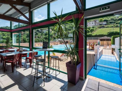 Maison 45m², Terrasse, Pour 6 Personnes - API-1-52-1033 في Saint-Rome-de-Tarn: مطعم فيه مسبح وطاولات وكراسي