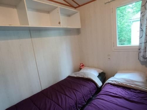 two beds in a small room with a window at Chalet de 28m² pour 4 personnes avec terrasse - API-1-52-1035 in Garindein
