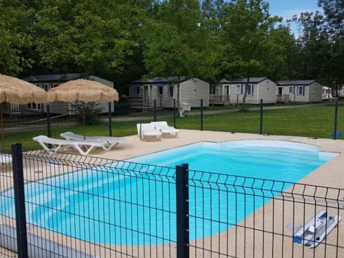a large blue swimming pool with chairs and umbrellas at Chalet de 28m² pour 4 personnes avec terrasse - API-1-52-1035 in Garindein