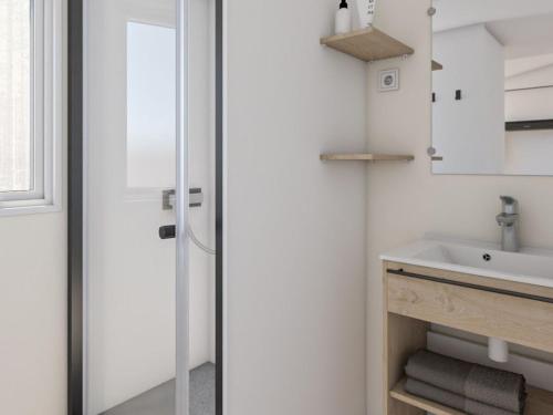 Mobile home avec Terrasse à Saint-Rome-de-Tarn - API-1-52-1049 في Saint-Rome-de-Tarn: حمام أبيض مع حوض ومرآة