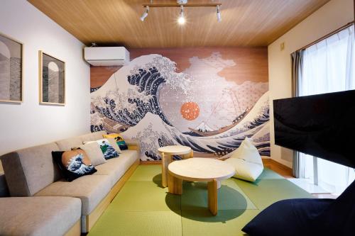 a living room with a large painting of a wave at Oneness House Kumamoto2 熊本新町2 in Kumamoto