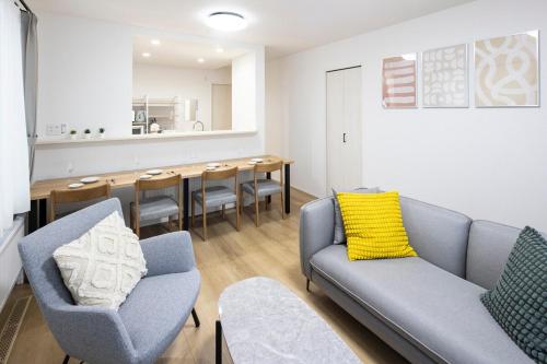 a living room with chairs and a dining room at T-Tarry Stay Villa in Sapporo