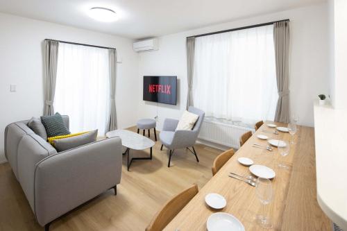 a living room with a table and a couch at T-Tarry Stay Villa in Sapporo