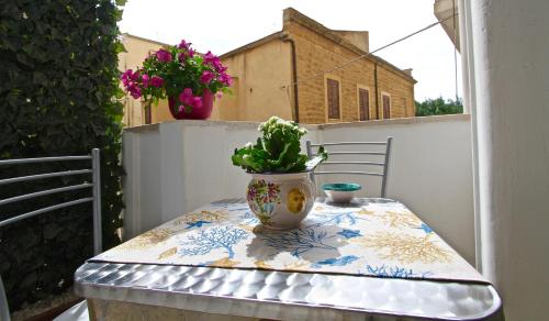 a table with a potted plant on a balcony at La Passeggiata di Girgenti in Agrigento