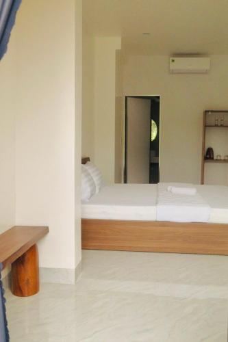 a bedroom with a large white bed with a mirror at Hiên's Homestay in Hue