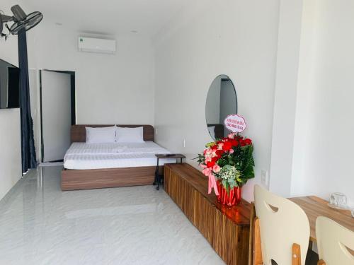 a bedroom with a bed and a table with flowers at Hiên's Homestay in Kon Rung (1)