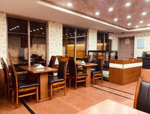 a dining room with wooden tables and chairs at MGallery Hotel in Srinagar