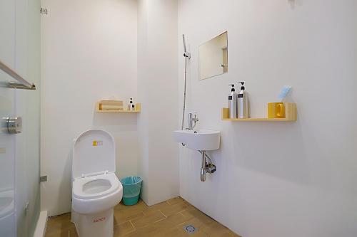 a small bathroom with a toilet and a sink at 英倫 旅店 in Tainan