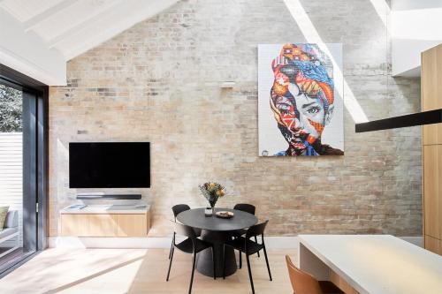 a living room with a table and a tv at Bondi Beach Premium Hideaway - Premium 2 bed apartment in Sydney