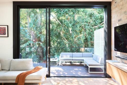 a living room with a large sliding glass door at Bondi Beach Premium Hideaway - Premium 2 bed apartment in Sydney