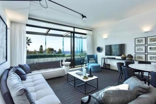 a living room with a white couch and a table at Luxury Bondi Beachside Apartment - Pacific in Sydney