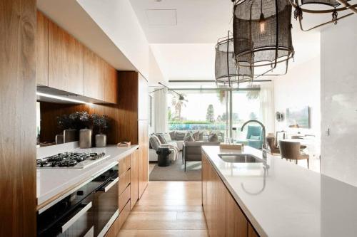 a kitchen with a sink and a stove top oven at Luxury Bondi Beachside Apartment - Pacific in Sydney