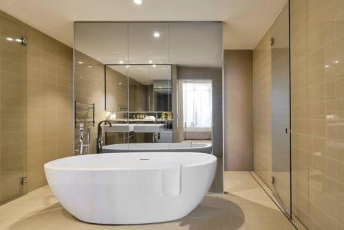 a large bathroom with a tub and a shower at Luxury Bondi Beachside Apartment - Pacific in Sydney