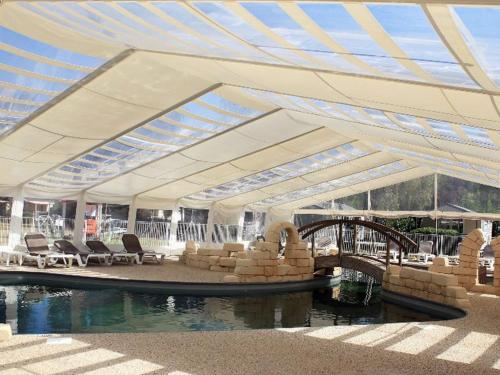 a pavilion with chairs and a bridge over a body of water at Mobil-home avec terrasse à Luynes - API-1-52-1072 in Luynes