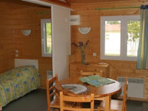 a room with a table and a bed and a bedroom at Chalet confortable avec terrasse - API-1-52-1104 in Charmes-sur-lʼHerbasse
