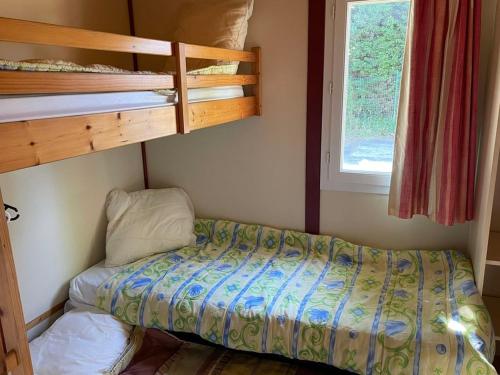 ein kleines Schlafzimmer mit einem Bett und Etagenbetten in der Unterkunft Chalet à Saint-Pierre-d'Oléron avec Terrasse - API-1-52-1111 in Dolus d'Oléron