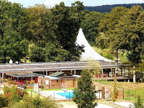 a large building with a large white roof at Mobil-home cosy avec terrasse à Loudéac - API-1-52-1116 in Loudéac