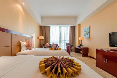 ein Hotelzimmer mit zwei Betten und einem Flachbildfernseher in der Unterkunft Qingdao Chengyang Detai Hotel in Qingdao