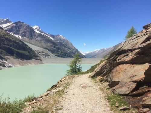 a dirt road next to a mountain lake at Chalet Stadel in Saas-Grund