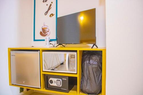 a tv on top of a yellow stand with a tv at Hotel Majo Sayulita in Sayulita