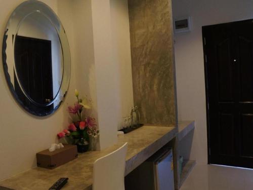 bagno con specchio e lavandino con fiori di Sabai @ Chumphae Hotel a Chum Phae
