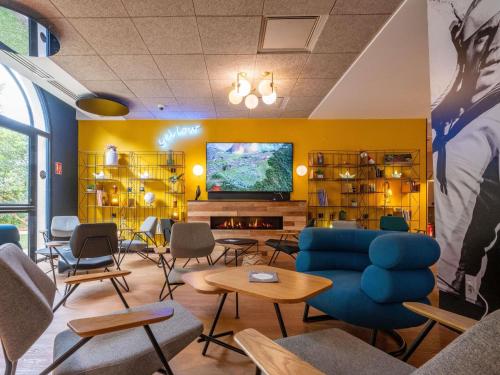 ein Wartezimmer mit blauen Stühlen und einem TV in der Unterkunft Novotel La Rochelle Centre in La Rochelle