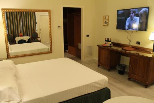a hotel room with two beds and a mirror at Hotel Don Carlo in Broni
