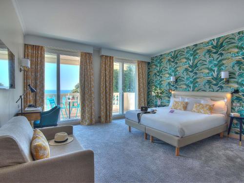 ein Schlafzimmer mit einem Bett und ein Wohnzimmer mit einem Sofa in der Unterkunft Mercure Nice Marché Aux Fleurs in Nizza