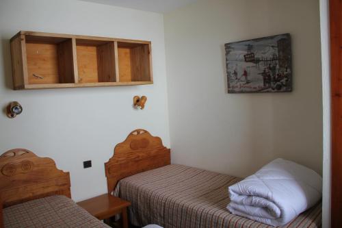 a small bedroom with two beds and a cabinet at Résidence Montana Premier in Val Thorens