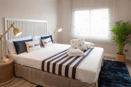 a bedroom with a large bed with blue and white pillows at MD Benlliure Beach. in Valencia